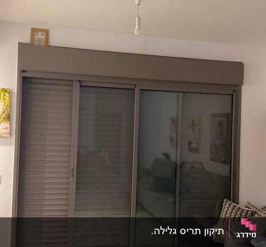 תריסים אפורים סגורים ליד חלון זכוכית